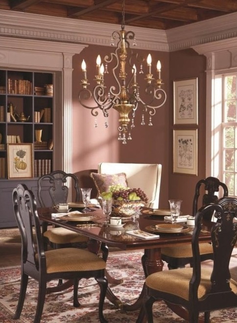 chandelier over a dining table that has flowers and plates