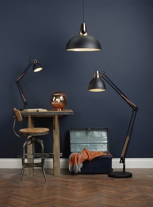 a selection of floor, table and pendant lights with a desk and a trunk