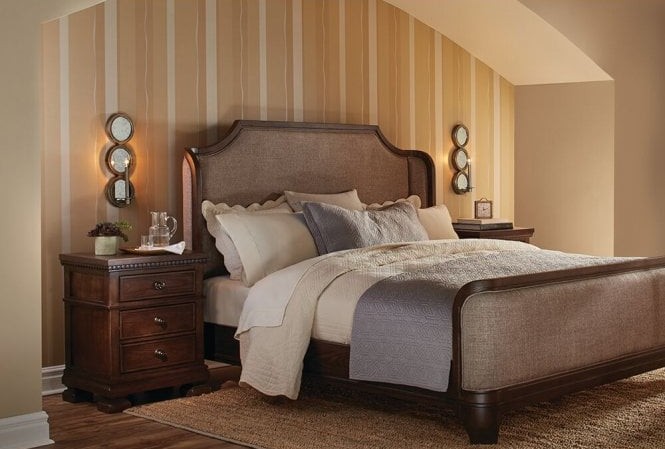 A bed with two bed side draws and wall lights