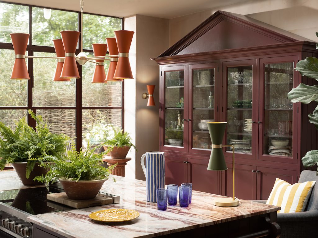 modern metal chandelier in orange with matching green table lamp