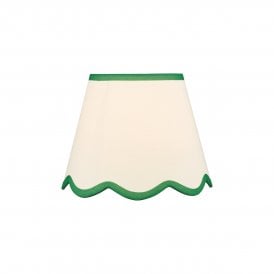 A neutral scalloped edge table lamp shade with green accent edging