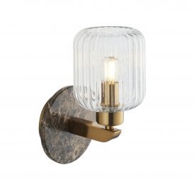 modern wall sconce in a brass finish with brown emperador marble backplate and ribbed glass shade